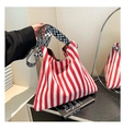Detail of red striped canvas tote bag featuring geometric patterned jacquard shoulder strap - Red