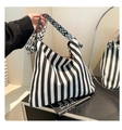 Detail of striped canvas tote bag featuring geometric wide strap and knotted handle design - Black