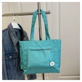 Dettaglio della borsa tote in nylon verde menta con tasca a zip e stemma rotondo - Blu Lago