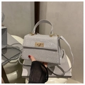 Detailed view of silver rhinestone handbag with gold-tone lock and sparkly texture - Silver