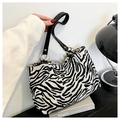 Dettaglio della borsa tote zebrata con manici in pelle nera e anelli in metallo dorato - Zebra Print
