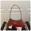 Détail du sac sous le bras en cuir rouge avec un élégant nœud décoratif en métal argenté - Rouge