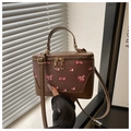 Detail der braunen Vintage-Eimertasche mit Kirschprint und Doppelreißverschluss im Sonnenlicht - Braun