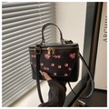 Detail der schwarzen Box-Beuteltasche mit Kirschprint und goldenem Doppel-Reißverschluss - Schwarz