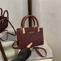 Borsa a tracolla bordeaux con stampa serpente, manici intrecciati e logo dorato - Rosso