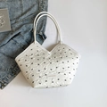 Chic white tote bag with quilted texture and black bow embroidery in a flat lay view - White Without Charm