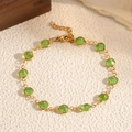 Dettaglio dell'elegante bracciale dorato con tredici pietre verdi circolari luccicanti - Verde (STB2541-GO-G)