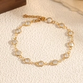 Dettaglio di bracciale a catena dorata con cristalli rotondi e chiusura a moschettone - Bianco (STB2541-GO-W)