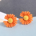 Fashionable orange daisy flower earrings with yellow centers on a blue display stand - Orange