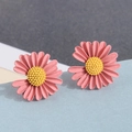 Chic pink daisy stud earrings with yellow centers and matte finish on geometric background - Pink