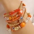 Close-up of Bohemian multilayer beaded bracelet with orange Hamsa and Evil Eye charms - Orange