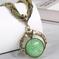 Detail of bohemian pendant necklace with green crackle stone and bronze relief patterns - Green