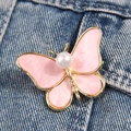 Elegante broche de mariposa dorada con esmalte rosa y perla sobre tela vaquera - Rosa