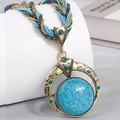Bohemian necklace featuring a round turquoise pendant set in an antique gold frame - Peacock Blue