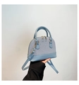 Detail of light blue shell bag featuring woven texture and smooth leather finish - Blue
