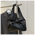 Close-up of the elegant large bow pleated design on this black faux leather handbag - Black