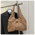 Macro detail of khaki bow-shaped tote bag with matte faux leather texture and pleats - Khaki