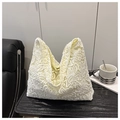 Primer plano de bolso de encaje beige con intrincadas texturas florales de ganchillo - Blanco