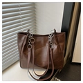 Detail of dark brown tote bag featuring geometric textured stitching and silver metal chain - Coffee