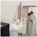 Détail du sac tissé avec rabat en cuir rose, chaîne dorée et fermoir rotatif sécurisé - Rose
