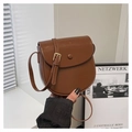 Dettaglio di una borsa a sella marrone a semicerchio con finiture dorate e tracolla - Marrone