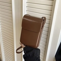 Vertikale dunkelbraune Crossbody-Handytasche aus glänzendem Leder mit minimalistischer Klappe - Braun
