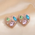 Elegant heart-shaped stud earrings with colorful crystals on champagne satin background - Pink