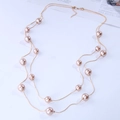 Elegant double-layer necklace featuring golden snake chains and champagne pearls on white base - Nude