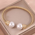 Elegante bracciale rigido dorato a treccia con grandi perle e micro diamanti luminosi - Oro