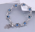 Detailansicht eines böhmischen Perlenarmbandes mit silbernen Hamsa-Hand- und Evil Eye-Anhängern - Auge und Palm Stil