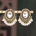 Dettaglio di orecchini vintage dorati con cristallo ovale e nappe di perle bianche - Bianco