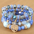 Vue macro du bracelet bohème à 4 couches avec cristaux bleus et pendentif cœur arbre - Bleu ciel