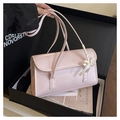 Close-up of pink ribbon bow detail on glossy leather shoulder bag in a gift box - Pink