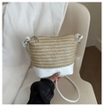 Detailaufnahme der Stroh-Eimertasche mit weißem Lederboden und Kordelzugverschluss - Weiß
