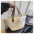 Detail der Stroh-Tragetasche mit weißer Spitzenschleife und braunem Ledergriff - Beige Mit Anhänger