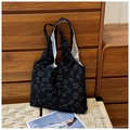 Detail of black fabric tote bag featuring 3D floral embroidery and integrated handles - Black