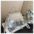 Close-up of metallic silver mini backpack with drawstring closure and logo detail - Silver