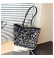Detail of black canvas tote bag with white cartoon graffiti and slim shoulder straps - Black without Pendant
