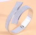 Slanke zilveren crossover armband met sterrenstofafwerking en scharniersluiting - Zilver