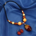 Elegantes Set aus Bernsteinschmuck und Ohrringen auf blauem Seidenhintergrund - Bernsteinharz-Stil