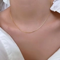 Minimalistische goldene Schlangenkette für Damen getragen mit weißem Hemd - Gold