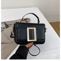 Dettaglio di borsa elegante in pelle nera con grande fibbia rettangolare dorata lucida - Nero
