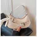 Detail der cremefarbenen Leder-Schultertasche mit Schnallen und Silberösen - Weiß