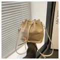 Detalle del bolso tipo cubo de ante beige con cierre de cordón y ojales dorados - Caqui