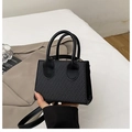 Minimalist black woven crossbody mini bag with textured finish and sleek leather handle - Black