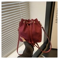 Detalle de bolso saco en ante color burdeos con cierre de cordón y ojales metálicos - Rojo