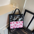 PVC-Einkaufstasche mit rosa Herzmuster, transparentem Oberteil und schwarzen Griffen - Rosa
