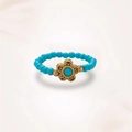 Close-up of a handmade elastic beaded ring with turquoise beads and a gold floral charm - J0406 Turquoise Freshwater Pearl Flower Ring