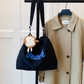 Bolso tote negro con cordón, letras Beach azules y un tierno colgante de peluche de pan - Con colgante de peluche de tostada / Negro