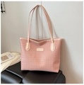 Detail of pink woven tote bag showing diamond texture and fashion brand label tag - Pink